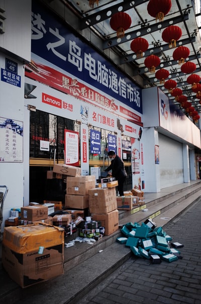 穿着黑衬衫和棕色裤子的女人站在棕色纸板箱前